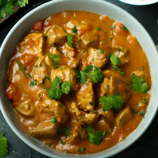 Kerala-style chicken curry garnished with fresh coriander at Kerala Restaurant Edmonton