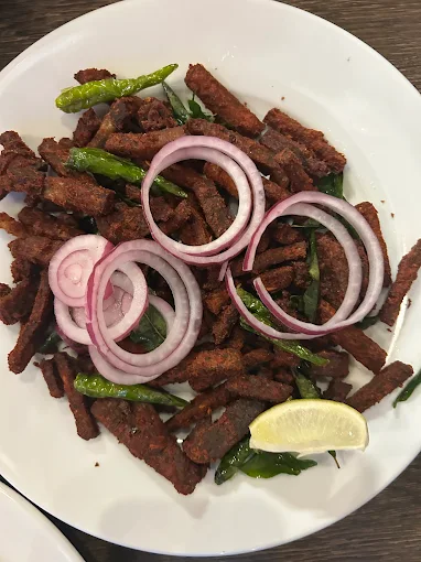Spicy Kerala beef fry with onion rings and green chillies at Kerala Restaurant Edmonton